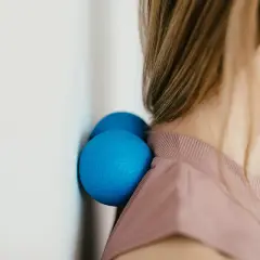 Due palline blu contro il muro aiutano a sciogliere i crampi al collo.