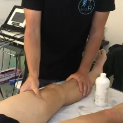 Fisioterapista massaggia un ginocchio, forse per alleviare i sintomi di calcificazione al ginocchio.