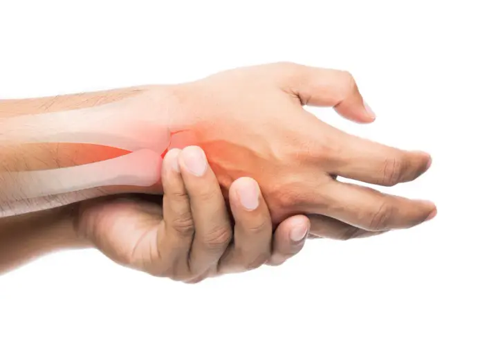 Mano che si tiene il polso, evidenziato in rosso, per indicare dolore al polso senza trauma.