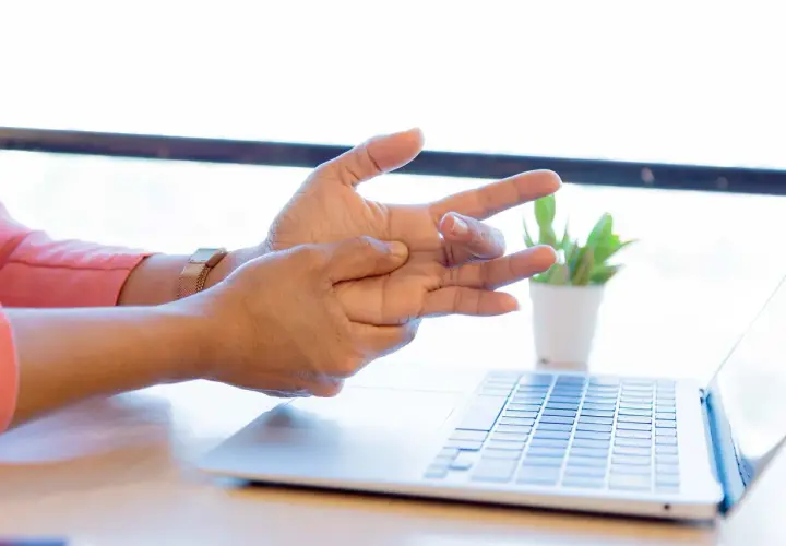 Mano che si massaggia il polso, forse per un dolore osso del polso causato dall'uso del computer.