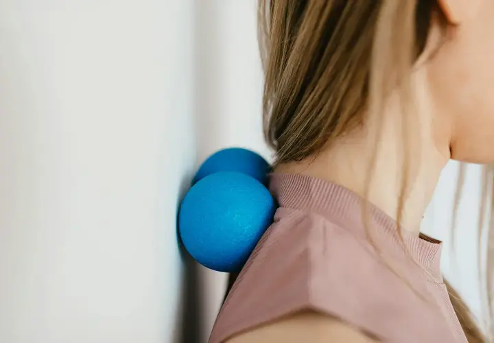 Due palline blu contro il muro aiutano a sciogliere i crampi al collo.