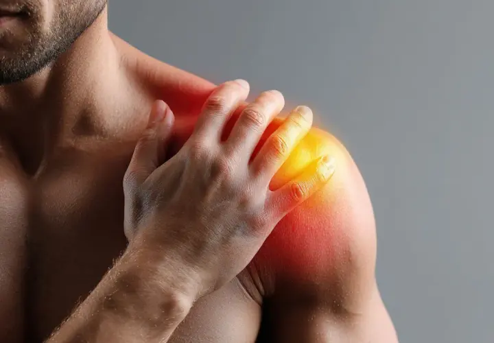 Uomo con mano sulla spalla dolente, evidenziata da rossore e calore. Dopo infiltrazione spalla bisogna stare a riposo per guarire.
