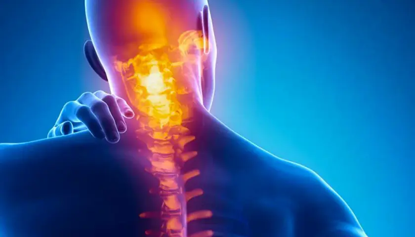 Dolore alla cervicale: un'illustrazione anatomica mostra la colonna vertebrale cervicale illuminata da un bagliore arancione, indicando infiammazione o dolore.