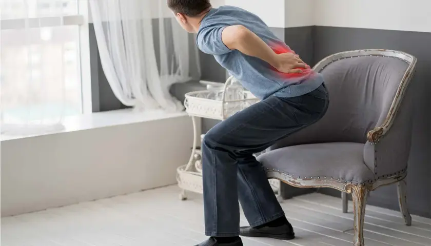 Uomo con lombalgia, evidenziata in rosso, che cerca rimedi.