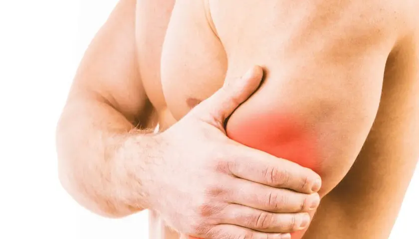 Uomo con mano sul braccio, evidenziata un'area rossa che indica infiammazione tricipite sintomi.