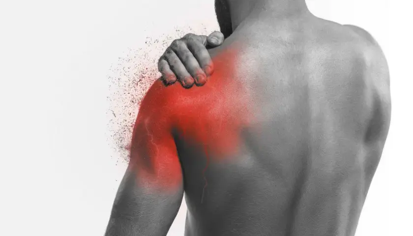 Uomo con mano sulla spalla, evidenziata in rosso, che simboleggia il dolore alla scapola quando respiro. Effetto di frammentazione.