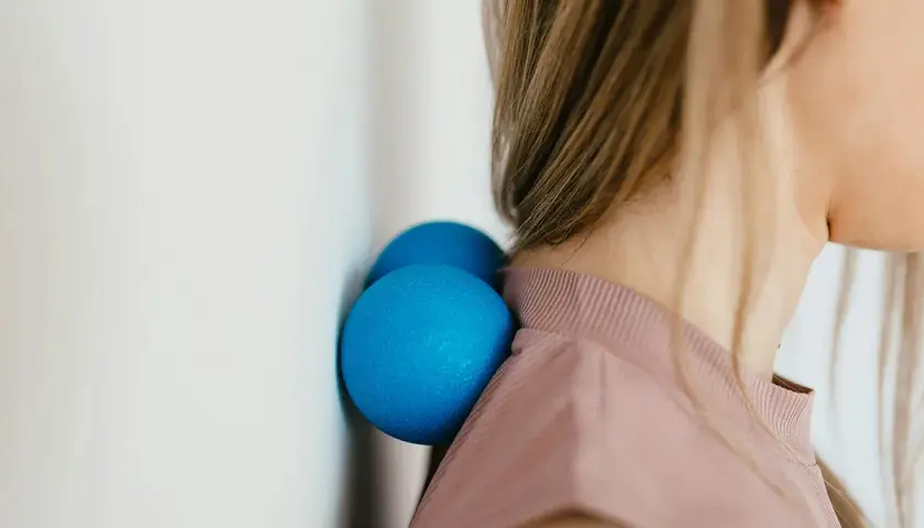Due palline blu contro il muro aiutano a sciogliere i crampi al collo.
