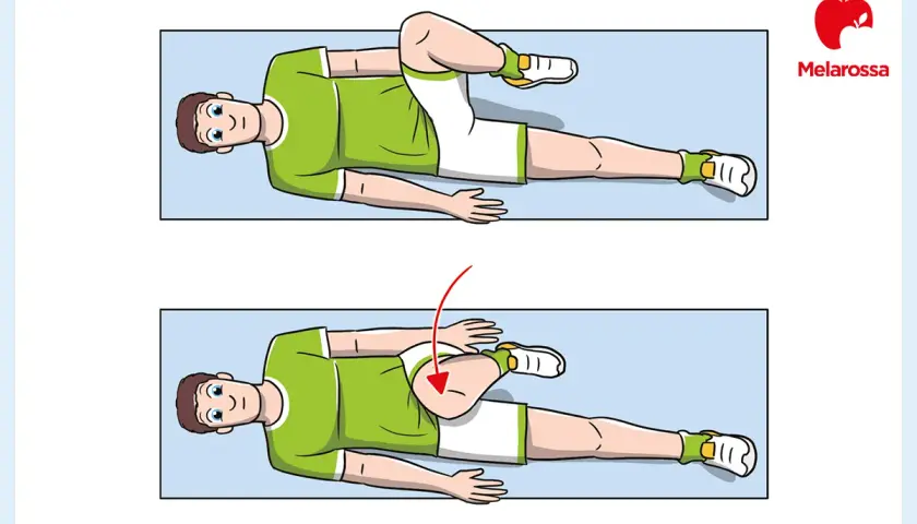 Uomo a terra esegue stretching per alleviare la pubalgia cronica. Gamba piegata porta il ginocchio verso il petto.