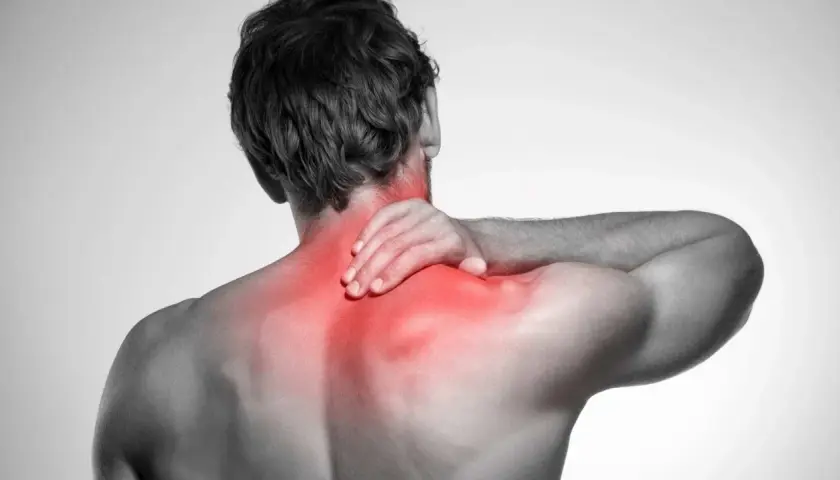 Uomo con mano sul collo, evidenziato in rosso il dolore ai tendini del collo e alle spalle.