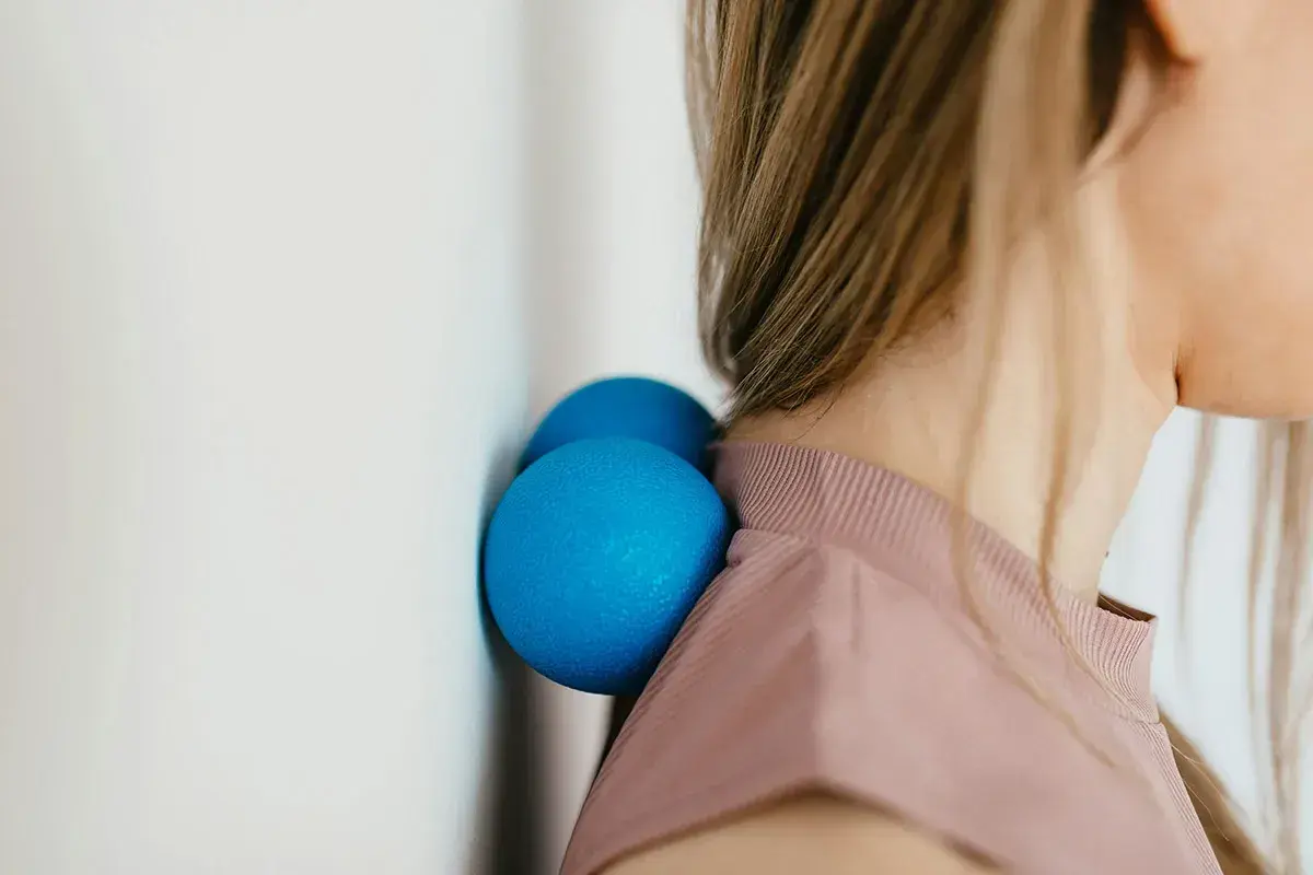 Due palline blu contro il muro aiutano a sciogliere i crampi al collo.