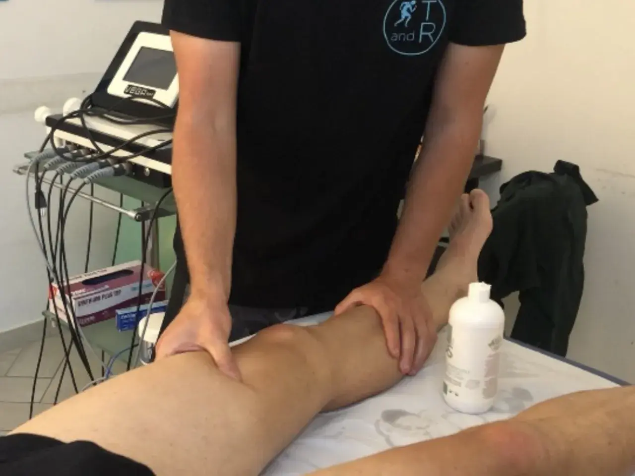 Fisioterapista massaggia un ginocchio, forse per alleviare i sintomi di calcificazione al ginocchio.